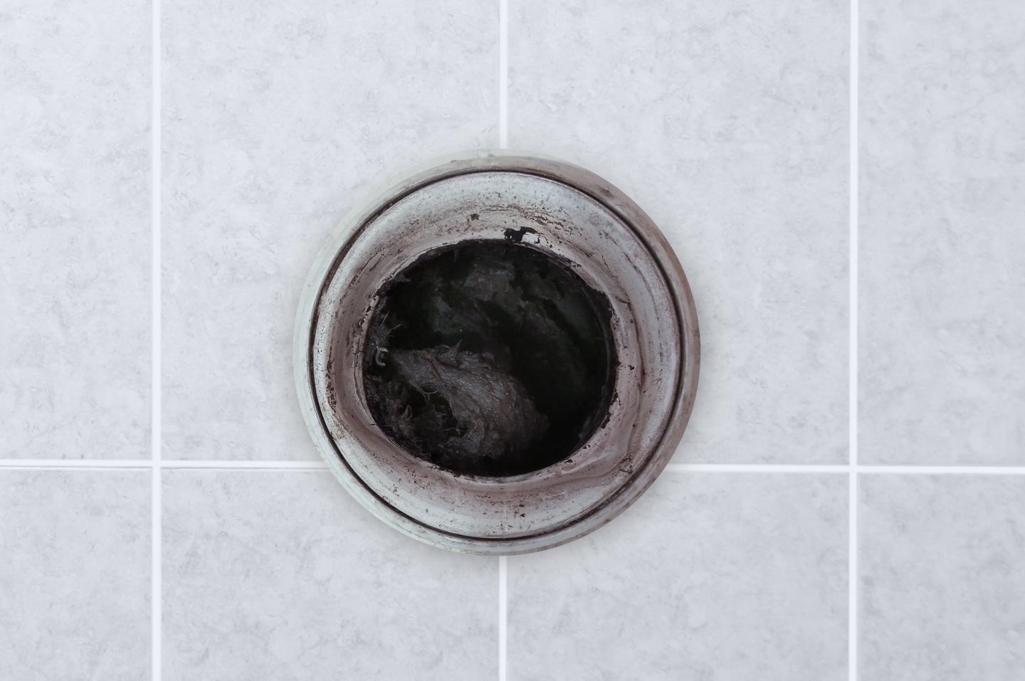 A Servpro technician is unclogging a dirty kitchen drain. The image shows the technician using specialized tools to clear the blockage and restore proper drainage. The scene emphasizes the importance of professional plumbing services in maintaining a clean and functional kitchen sink