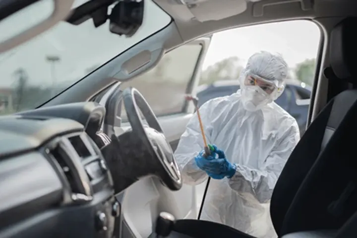 Person with a sprayer cleaning inside car